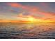 Stunning sunset over the ocean with a distant cityscape and vibrant colors in the sky at 6106 Marbella Blvd, Apollo Beach, FL 33572