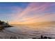 Scenic waterfront view featuring a sandy beach, rocky coast, and a colorful sunset sky at 6106 Marbella Blvd, Apollo Beach, FL 33572