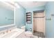 Well-lit bathroom with blue walls, marble countertop, tiled shower, and storage shelves at 6408 Bonnie Bay N Cir, Pinellas Park, FL 33781