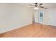 Spacious bedroom with wood-look floors, ceiling fan, and access to bathroom and closet at 6408 Bonnie Bay N Cir, Pinellas Park, FL 33781