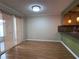 Dining area with laminate flooring, sliding doors with bamboo-style privacy shades, and a passthrough to the kitchen at 6408 Bonnie Bay N Cir, Pinellas Park, FL 33781