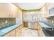 Well-equipped kitchen featuring updated appliances, mosaic tile backsplash, ample counter space, and light wood cabinets at 6408 Bonnie Bay N Cir, Pinellas Park, FL 33781