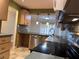 Well-lit kitchen with light wood cabinets, mosaic backsplash, stainless dishwasher, and open access to the dining area at 6408 Bonnie Bay N Cir, Pinellas Park, FL 33781