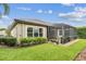 Beautifully landscaped backyard featuring a screened-in porch and lush green grass at 6642 Current Dr, Apollo Beach, FL 33572