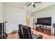 Bonus room featuring two recliners, a large TV, wood floors, and a ceiling fan at 6642 Current Dr, Apollo Beach, FL 33572