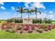 Community entrance sign surrounded by lush landscaping and vibrant flowers at 6642 Current Dr, Apollo Beach, FL 33572