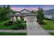 Charming single-story home with a well-manicured lawn and a two-car garage on a sunny day at 6642 Current Dr, Apollo Beach, FL 33572