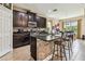 Well-equipped kitchen with dark cabinetry, granite countertops, stainless appliances, and breakfast bar seating area at 6642 Current Dr, Apollo Beach, FL 33572