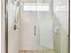 Modern shower featuring glass doors, a rainfall shower head, and bright, neutral tile at 6642 Current Dr, Apollo Beach, FL 33572