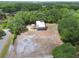 Aerial view of house with metal roof, surrounded by lush trees, and large yard at 7606 Four Pines Rd, Plant City, FL 33565