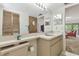 Bathroom with a large mirror, neutral fixtures, and a storage shelf, offering functionality and convenience at 7606 Four Pines Rd, Plant City, FL 33565