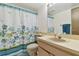 Cozy bathroom with blue dragonfly patterned shower curtain and well lit mirror at 7606 Four Pines Rd, Plant City, FL 33565