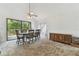 Bright dining room with vaulted ceiling, ceiling fan, and sliding glass doors to a wooden deck at 7606 Four Pines Rd, Plant City, FL 33565