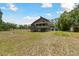 Exterior of home on stilts with decks, complemented by a spacious yard and lush greenery at 7606 Four Pines Rd, Plant City, FL 33565