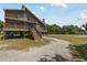 Gorgeous raised two-story home featuring wooden decks and staircase on spacious lot with driveway at 7606 Four Pines Rd, Plant City, FL 33565