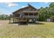 Exterior home featuring a balcony, decks, and a spacious lot enhanced with lush greenery at 7606 Four Pines Rd, Plant City, FL 33565