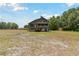 Exterior of home on stilts with decks, complemented by a spacious yard and lush greenery at 7606 Four Pines Rd, Plant City, FL 33565