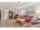 Inviting living room featuring a comfortable red sofa and lots of natural light at 7606 Four Pines Rd, Plant City, FL 33565