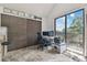 Home office with desk, computer setup, shelving, and sliding glass doors to the exterior balcony at 7606 Four Pines Rd, Plant City, FL 33565