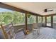 Charming screened-in porch with rocking chairs, offering a serene space to enjoy the surrounding greenery at 7606 Four Pines Rd, Plant City, FL 33565