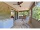 A covered screened-in porch with two chairs and a view of the greenery, great for relaxing outdoors at 7606 Four Pines Rd, Plant City, FL 33565