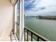 Waterfront view from a balcony with a black railing and tall buildings in the distance at 7645 Sun Island S Dr # 304, South Pasadena, FL 33707