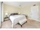 Bright bedroom featuring neutral carpet and white ceiling fan with a tufted bench at the foot of the bed at 7645 Sun Island S Dr # 304, South Pasadena, FL 33707