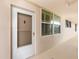Exterior hallway view of the entrance to unit 304 with an entrance door and windows at 7645 Sun Island S Dr # 304, South Pasadena, FL 33707