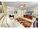 Bright living room showcasing plantation shutters, a ceiling fan, and a mirrored wall for an open feel at 7645 Sun Island S Dr # 304, South Pasadena, FL 33707