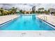 Large outdoor swimming pool with clear blue water, surrounded by lounge chairs and lush greenery at 7645 Sun Island S Dr # 304, South Pasadena, FL 33707