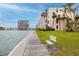 Scenic waterfront view of the community and lush landscaping, with convenient bench at 7645 Sun Island S Dr # 304, South Pasadena, FL 33707