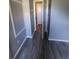 Hallway with modern flooring, neutral walls, and an open doorway at 8440 Old Post Rd # 104, Port Richey, FL 34668