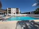 Enjoy the community pool surrounded by lounge chairs and white fencing at this condominium at 8440 Old Post Rd # 104, Port Richey, FL 34668