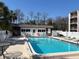 Community pool featuring clear blue water, lounge chairs, and well-kept surrounding grounds at 8440 Old Post Rd # 104, Port Richey, FL 34668