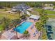 A birds eye view of a community pool, tennis court, palm trees, and ample seating around the pool at 9375 French Quarters Cir, Weeki Wachee, FL 34613