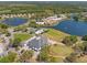 An aerial view showcases community amenities like the clubhouse, pool, tennis courts, lakes, and putting green at 9375 French Quarters Cir, Weeki Wachee, FL 34613