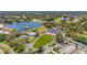 An aerial view shows a golf course, a pond, a swimming pool, and tennis courts in a residential area at 9375 French Quarters Cir, Weeki Wachee, FL 34613