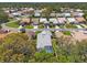 An aerial view shows houses in a well-maintained residential neighborhood with lush landscaping and mature trees at 9375 French Quarters Cir, Weeki Wachee, FL 34613