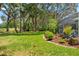Landscaped backyard with lush lawn and colorful garden beds, offering a peaceful retreat at 9375 French Quarters Cir, Weeki Wachee, FL 34613