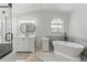 Bathroom boasting a soaking tub, walk-in shower, and stylish vanity at 9375 French Quarters Cir, Weeki Wachee, FL 34613