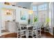 Bright dining room featuring a modern chandelier, bay windows, and an adjacent kitchen at 9375 French Quarters Cir, Weeki Wachee, FL 34613