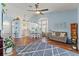 Open-concept living room with hardwood floors, a ceiling fan, and a view of the kitchen at 9375 French Quarters Cir, Weeki Wachee, FL 34613