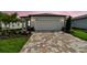 Charming home exterior with a brick driveway and attached two-car garage at 9408 Coastline Way, Parrish, FL 34219