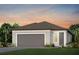 Charming single-story home showcasing a neutral color palette, gray roof, and a well-manicured lawn with tropical landscaping at 9408 Coastline Way, Parrish, FL 34219