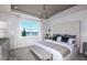 Serene main bedroom with a tufted headboard, chandelier, and a picturesque view of the lake at 9408 Coastline Way, Parrish, FL 34219
