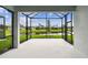 Screened-in patio with a view of the backyard pond and landscaping at 9408 Coastline Way, Parrish, FL 34219