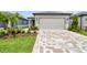 Charming single-Gathering home featuring a neatly landscaped front yard and a paved driveway leading to a two-car garage at 9530 Coastline Way, Parrish, FL 34219
