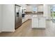 Open kitchen featuring stainless steel appliances, white cabinets, a stylish backsplash, a center island, and a sliding glass door at 9530 Coastline Way, Parrish, FL 34219