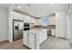 Bright kitchen featuring a large island, stainless steel appliances, white cabinets, and a sliding glass door at 9530 Coastline Way, Parrish, FL 34219