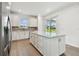 Bright kitchen featuring a center island, stainless steel appliances, white cabinets, and a sliding glass door at 9530 Coastline Way, Parrish, FL 34219